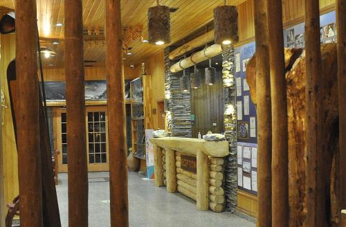 a room with wooden walls and a counter with logs at Inan Kardesler Hotel in Uzungöl