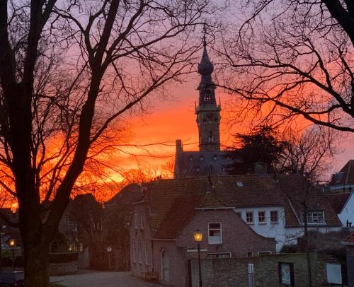 a building with a clock tower at sunset at Logies Zen & Zilt Veere in Veere