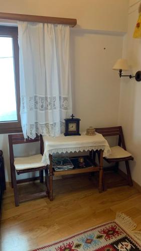 a room with a table and two chairs and a window at Ξύλο & Παράδοση in Pávliani