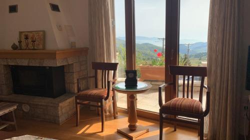a living room with two chairs and a fireplace at Ξύλο & Παράδοση in Pávliani