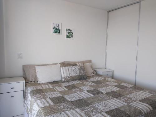 a bedroom with a bed with a quilt on it at Increíble departamento en Luján de Cuyo, imponente vista a la montaña in Ciudad Lujan de Cuyo