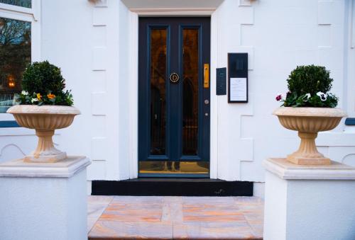 two vases in front of a door of a building at Domo Boutique Hotel in Oldbury