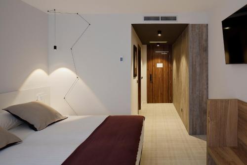 a bedroom with a bed and a hallway at NUMA HOTEL BOUTIQUE in Gijón