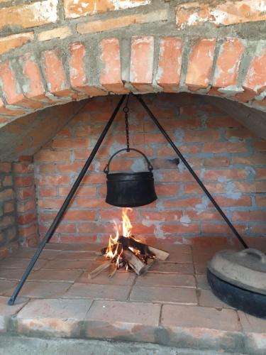 a pot hanging over a fire in a brick oven at Vikendica RANKOVIĆI in Mokra Gora