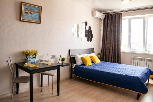 ノヴォロシースクにあるАпартаменты Мильфей 19-3のベッドルーム1室(ベッド1台、テーブル付)、ダイニングルームが備わります。