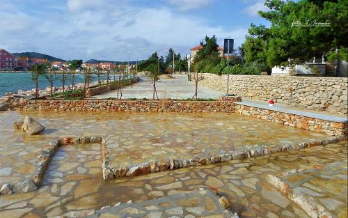 a stone walkway next to a body of water at Lavanda in Poljana