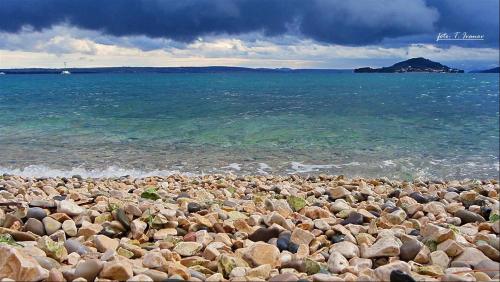 a large group of rocks on a beach near the water at Lavanda in Poljana