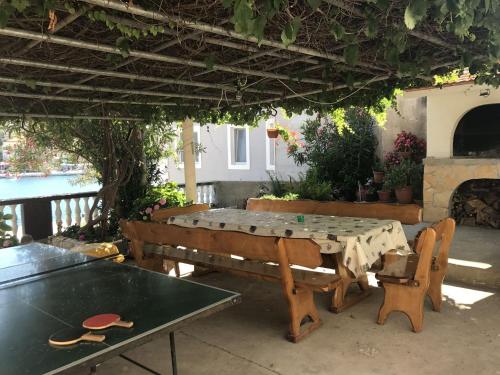 a patio with a table and benches and a fireplace at Apartments Svetka - 10m from the sea in Sali