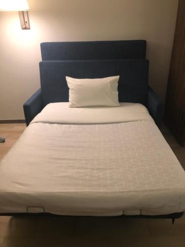 uma cama branca com uma cabeceira azul e uma almofada branca em Holiday Inn Express & Suites - Playa del Carmen, an IHG Hotel em Playa del Carmen