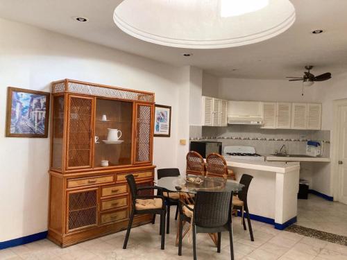 a dining room with a table and chairs and a kitchen at Aca Suites Ixtapa in Ixtapa