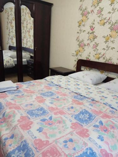 a bed with a colorful quilt on it in a bedroom at Apartment Chernihivska 13 in Shostka