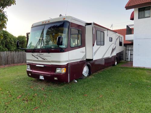 an rv parked in a yard next to a house at Cozy Private Motorhome near The Falls & Baptist with Parking in Miami