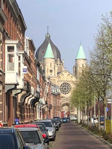 una calle con coches aparcados frente a una catedral en Chez Hélène Luxury BNB, en Maastricht