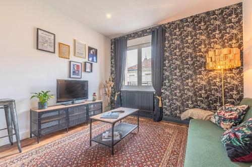 een woonkamer met een bank en een tv bij Chez Côme in Metz