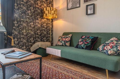 un salon avec un canapé vert et une table dans l'établissement Chez Côme, à Metz