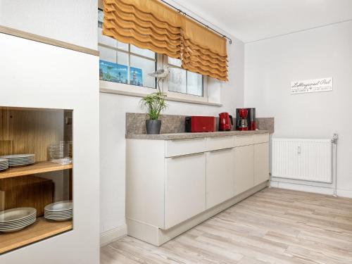 a kitchen with white cabinets and a window at Souterrain Wohnung Seegras in Insel Poel