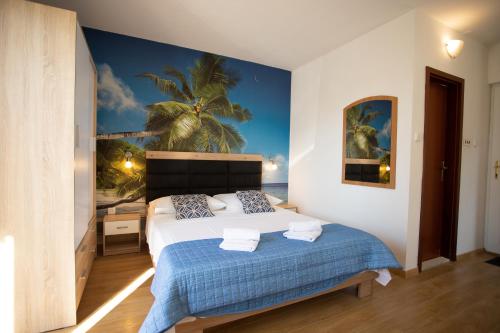una camera da letto con un letto dipinto a muro con palme di Bol apartments Gospojica a Bol