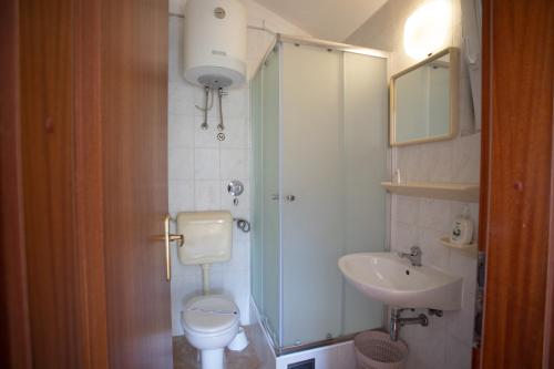 un bagno con lavandino, WC e doccia di Bol apartments Gospojica a Bol