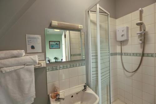 a bathroom with a shower and a sink and a mirror at Airdenair Guest House in Edinburgh