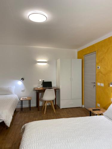 sypialnia z 2 łóżkami i biurkiem z komputerem w obiekcie B&B The Secret Place w mieście Cavedago