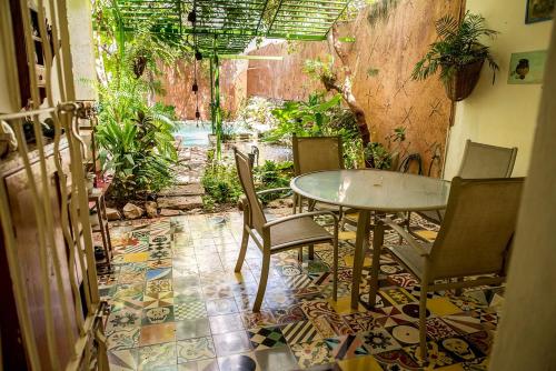 a table and chairs in a room with a tile floor at La Selva by Majikal B&B in Mérida