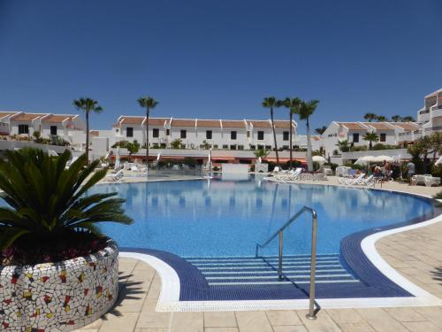 a large swimming pool in a resort with palm trees at Vivienda Vacacional Parque Santiago 1 Bernal Home in Arona
