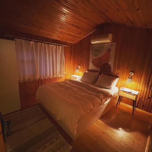 a bedroom with a bed with a painting on the wall at Kibala Hotel in Cıralı