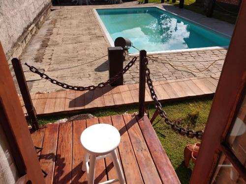 a wooden deck with a chain around a swimming pool at Chalé de madeira in Santa Cruz de Minas