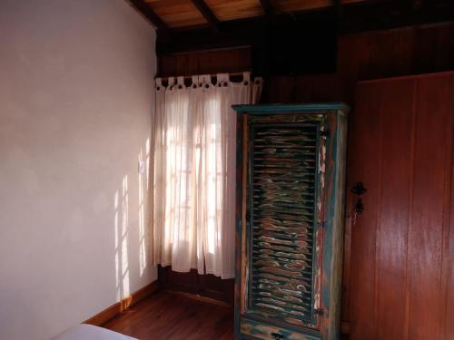 a room with a window and a curtain at Chalé de madeira in Santa Cruz de Minas