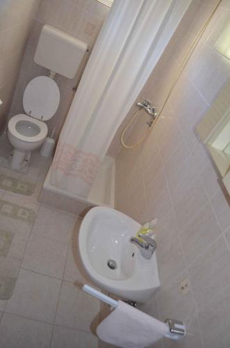 a bathroom with a white toilet and a sink at Palit Apartment 2 in Palit
