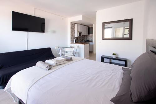 Un dormitorio con una cama blanca con toallas. en Dream Studio in Benalmadena Costa del Sol, en Benalmádena