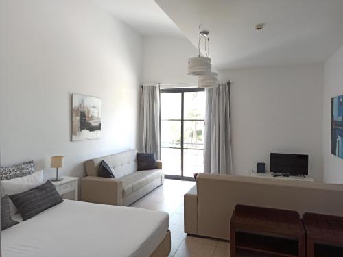 a white living room with a bed and a couch at APC Apartamento Palmela Village in Palmela