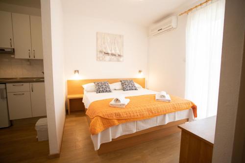 una camera da letto con un letto con due asciugamani sopra di Bol Studio Gospojica a Bol