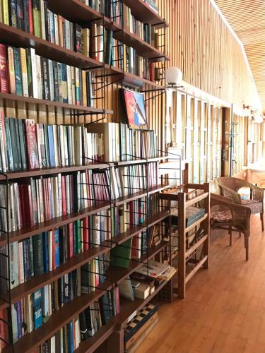 a library with many shelves filled with books at Kibala Hotel in Cıralı