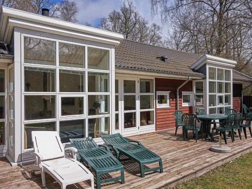 a screened in porch with chairs and a table at 10 person holiday home in Hasle in Hasle