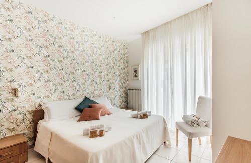a bedroom with a white bed with a floral wallpaper at In Centro Residenza - Suites & Apartments in Vasto
