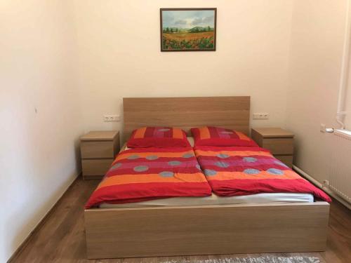 1 dormitorio con 1 cama con edredón rojo y naranja en Apartment Balatonbereny 9, en Balatonberény