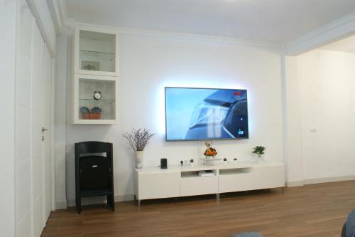 salon z telewizorem na białej ścianie w obiekcie APARTAMENTO LEVIES w Sewilli