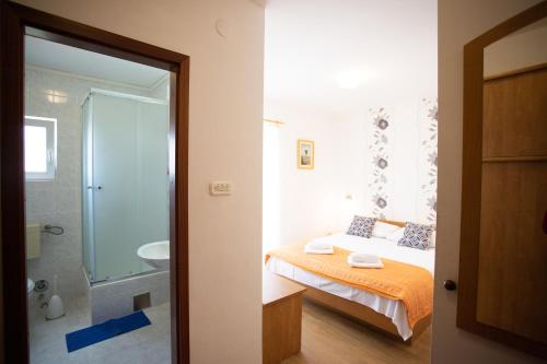una camera da letto con un letto e un bagno con doccia di Bol Studio Gospojica a Bol