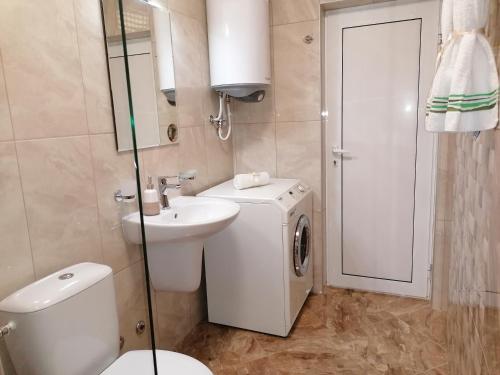 a bathroom with a toilet and a sink and a mirror at Megi Luxury Apartments in Pomorie