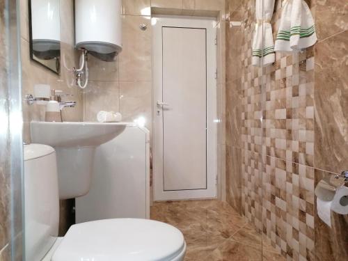 y baño con aseo y lavamanos. en Megi Luxury Apartments, en Pomorie