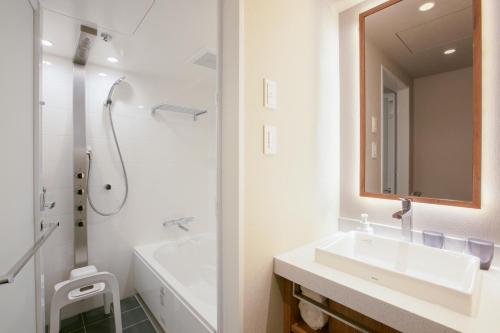a white bathroom with a sink and a shower at Hotel Forza Osaka Namba in Osaka