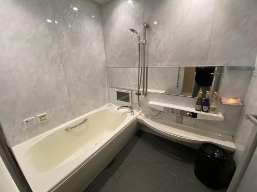 a white bathroom with a tub and a sink at リバーサイド in Imabari