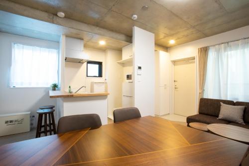 a living room with a wooden table and chairs at Laffitte Tokyo WEST in Tokyo