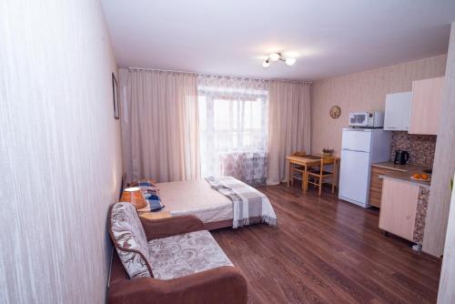 a small room with a bed and a kitchen at Studio on Molodogvardeytsev 76, Academ Riverside in Chelyabinsk