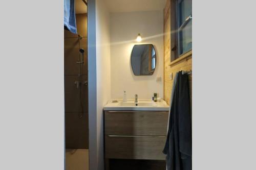 une salle de bain avec un lavabo et un miroir dans l'établissement Gîte familial Baie de Somme 8 personnes, à Rue