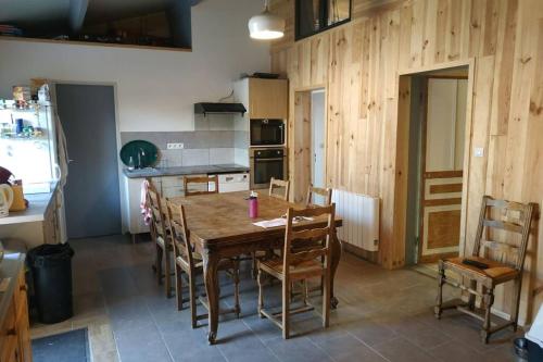 une cuisine avec une table en bois et quelques chaises dans l'établissement Gîte familial Baie de Somme 8 personnes, à Rue