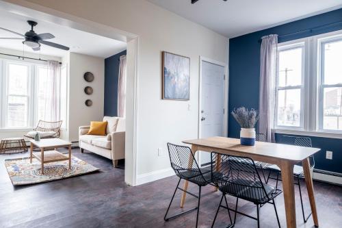 Providence Modern, Comfy 3BR Apartment في بروفيدينس: غرفة معيشة بجدران زرقاء وطاولة وكراسي