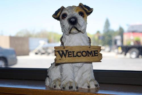a statue of a dog holding a welcome sign at AmeriVu Inn and Suites Shawano WI in Shawano