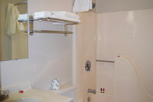 a white bathroom with a sink and a mirror at AmeriVu Inn and Suites Shawano WI in Shawano